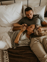Fototapeta premium Beautiful loving couple kissing in bed