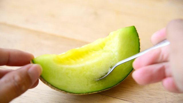 Lap the Fresh green melon on wood plate by spoon