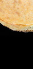 Fried pancakes. The texture of the dough. A treat on Shrove Tuesday. Culinary products on a black background.