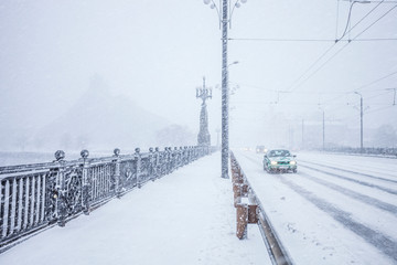 Fototapeta premium Traffic on snow covered bridge during heavy snow storm