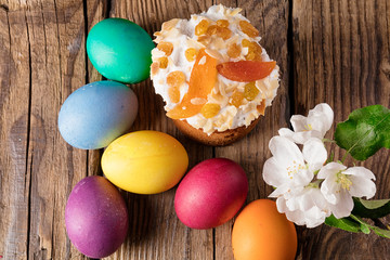 Easter cake and painted eggs on wooden table