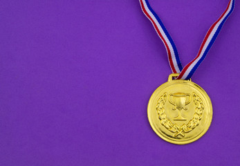 Golden medal on purple background with copy space
