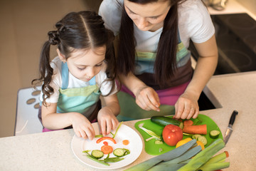Obraz na płótnie Canvas Pretty mother and her child making vegetable salad