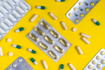 colorful pills and tablets on yellow background