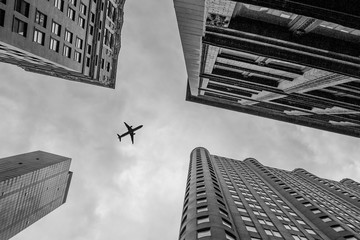 Up view with airplane in financial district, Manhattan, New York