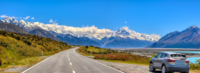 The panorama of the mountains and the lake pukaki during the summer, when the sky is clear, cars parked on the side of the road in Mount Cook National Park in south island of New Zealand
