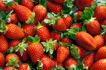 Fresh strawberries with leaves background