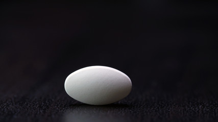 one white tablet is isolated on a black background.