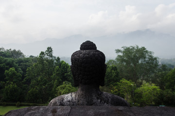 Estatua de Buda en el templo de Borobudur con vistas a la naturaleza