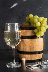 the still life with white wine, glass and old barrel