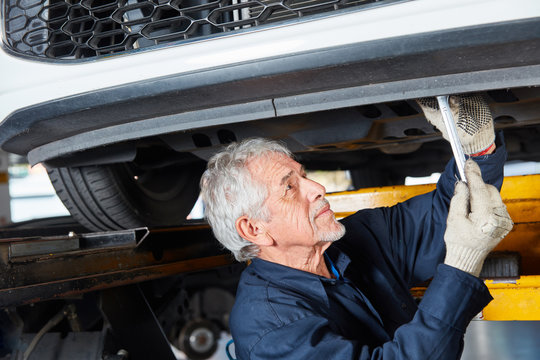 Old Experienced Car Mechanic Repairs Car