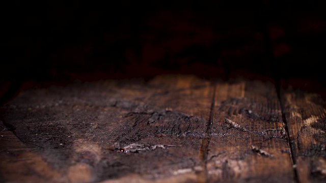 Close up of dark natural brown wooden texture. Stock footage. Old rustic table with cracks, timber background.