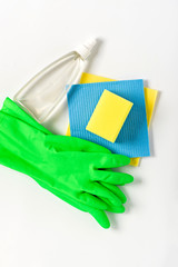 Spring cleaning home concept. Green gloves, yellow sponge, blue rag and glass cleaner on a white background, top view, flat lay. Household.