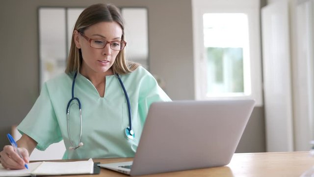 Portrait of nurse working on laptop computer