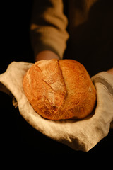 Woman Holding A Loaf Of Bread. Close-up of a woman holding a loaf of home-baked bread.