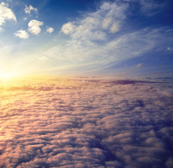 Fototapeta na wymiar Sunrise above clouds from airplane