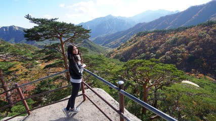 Fototapeta na wymiar Young woman on the top of Ulsanbawi mountain in a Seoraksan National Park in South Korea, Asia.