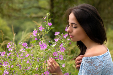 Pretty woman smelling flowers