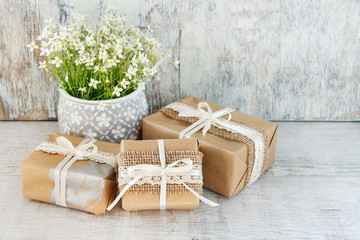 Beautifully wrapped gifts and floral decoration in the background.
