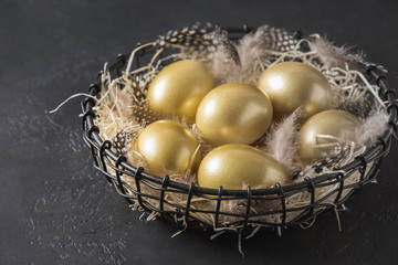 Chicken colored golden eggs in decorative vase on black. Easter dark concept.