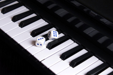 Two dice on black and white piano keys. Black and white lanes of life. Life is game.