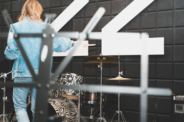 Creativity and music. Young beautiful girl plays the drums. Recording Studio. Musical equipment.