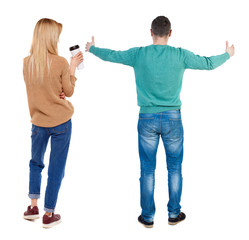 Back view of couple in sweater showing thumbs up.
