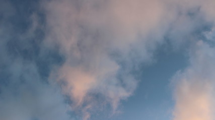 Fototapeta na wymiar blue sky with pink clouds and breath of wind