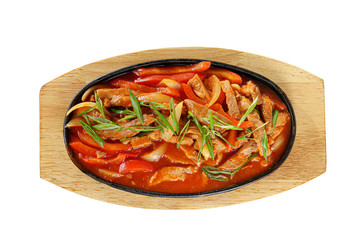 Potatoes with meat, beef, lamb, zucchini, tomato and onion, with sweet and sour sauce, fried, baked portion on a hot frying pan, on a wooden board on white background view from above. For the menu