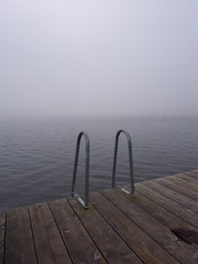 Fototapeta premium swimming ladder by the lake on a misty day