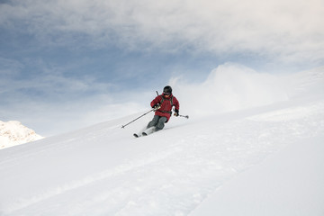 Fototapeta na wymiar Man on a ski gliding on a snowy mountain