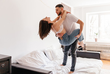 sexy couple at home. Woman in lingerie kissing, hugging and playing with her husband