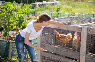 Smiling young female proffesional farmer  near chicken house