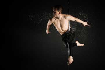 Portrait of professional male model performing a pole dance