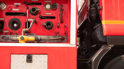 Gauge pressure and valve lever with high pressure fire safety pump on side view of red fire truck