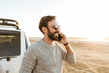Smiling handsome young man using mobile phone