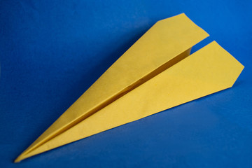 Yellow paper plane on a blue background