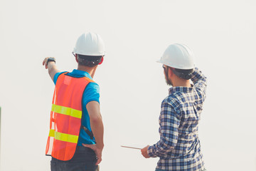Engineer and businees man pointing and looking forward with hope and keep going at construction site.