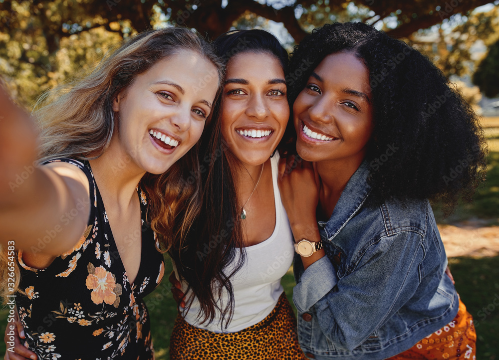 Canvas Prints close-up self portrait of smiling young multiethnic female friends taking selfie in the park - women