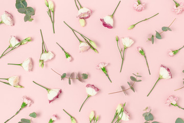 Pattern made of eustoma, carnation flowers and eucalyptus. Floral composition on a pink pastel background.