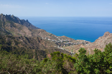 Fototapeta na wymiar Aerial view of the small village surrounded with Anaga mountains on the Atlantic ocean background, Tenerife, Canary Islands, Spain.