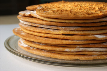 Round baked cake layers stacked on a plate. Homemade cooking honey cake.