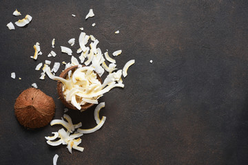 Coconut and coconut chips on a dark concrete background.