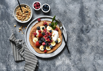 Crepe with berries and yogurt for breakfast. Breakfast on the kitchen table top view.