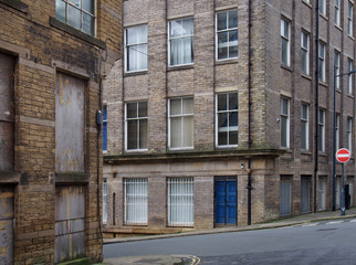 Fototapeta premium a street corner view of closed and boarded up old abandoned industrial and office buildings in the little germany area of bradford