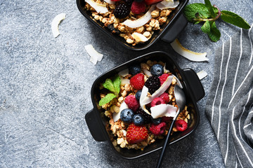 Granola with nuts, honey and berries for breakfast. Breakfast on the kitchen table, top view with place for text.