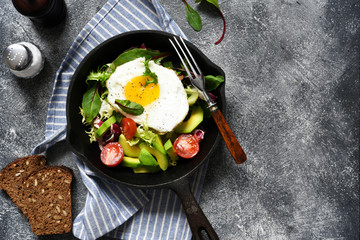 Salad with tomatoes and avocado, fried in a pan for breakfast.