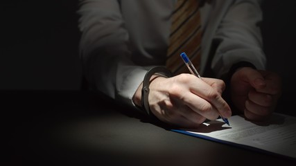Businessman Wearing Formal Clothing Signs A Document With Hands Handcuffed