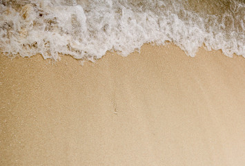 Fototapeta na wymiar Wave hits the white sand beach