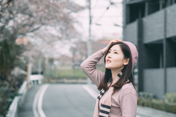 Obraz premium Under the cherry tree, the girl smiles gently